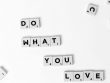 Scrabble tiles spelling 'Do What You Love' on a white background, encouraging creativity.