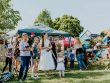A lively outdoor gathering with families enjoying balloons and a sunny day.
